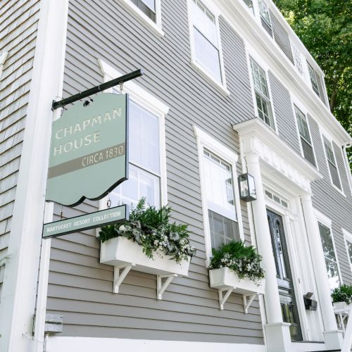 A Chapman House sign hangs on the side of a white building, reading &ldquo;Nantucket Resort Collection&rdquo; and &ldquo;CIRCA 1830.&rdquo;