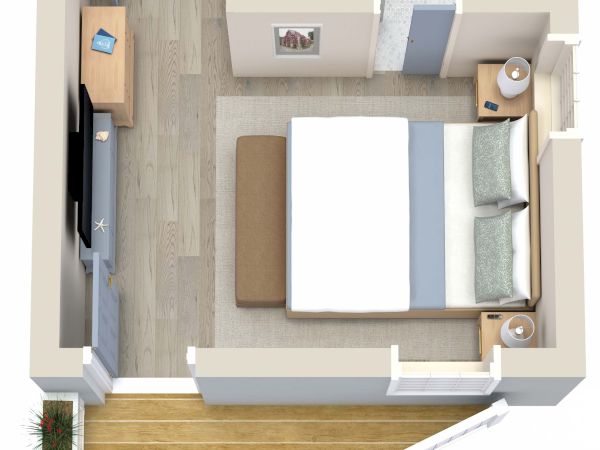This image shows a small bedroom with a double bed, nightstands, a television, a desk, a bathroom, and a small outdoor deck along one wall.
